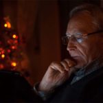 Une personne âgée regarde les actualités sur sa tablette la nuit.