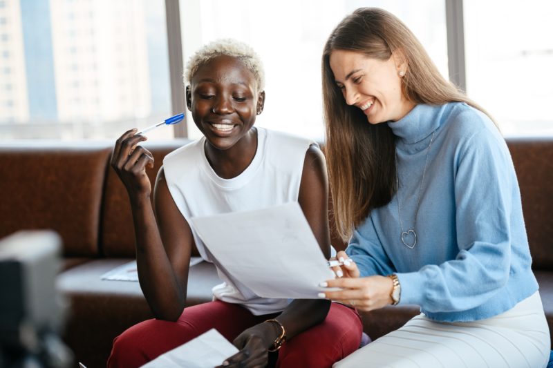 Deux femmes lisant une feuille.